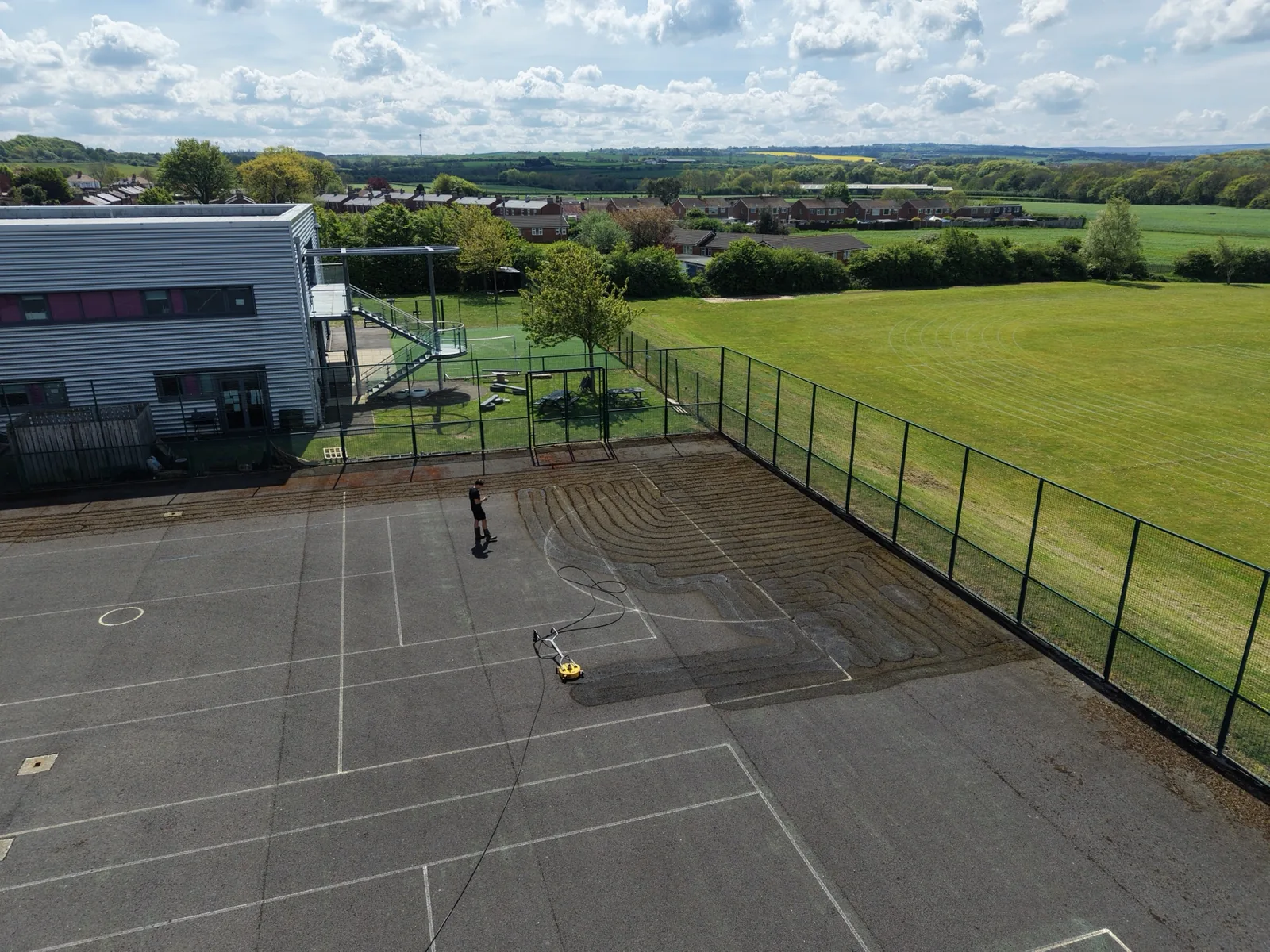 Aerial view of active Freebrough Academy tennis-court cleaning work