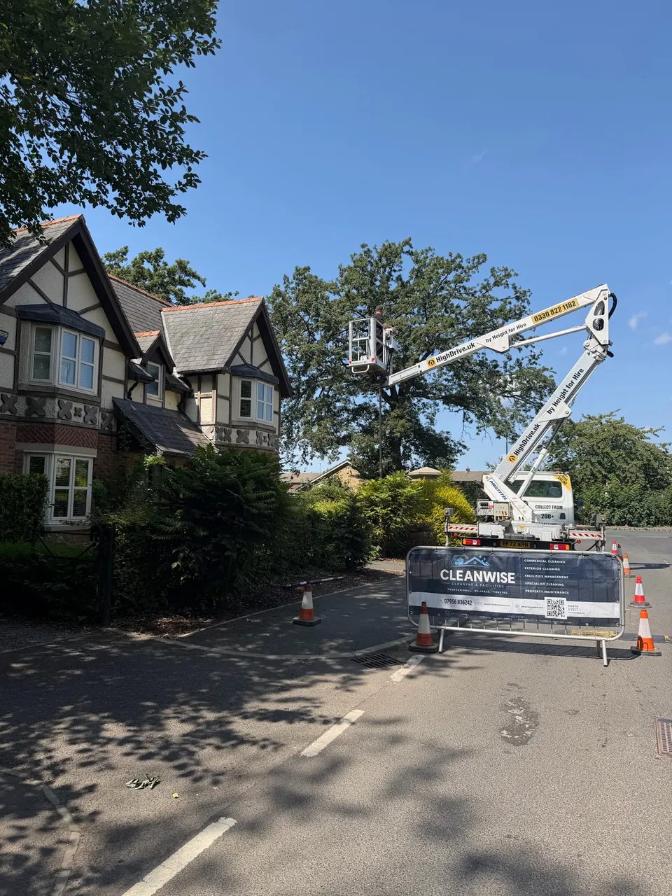 CLEANWISE commercial cleaning work zone with access equipment and a branded site barrier